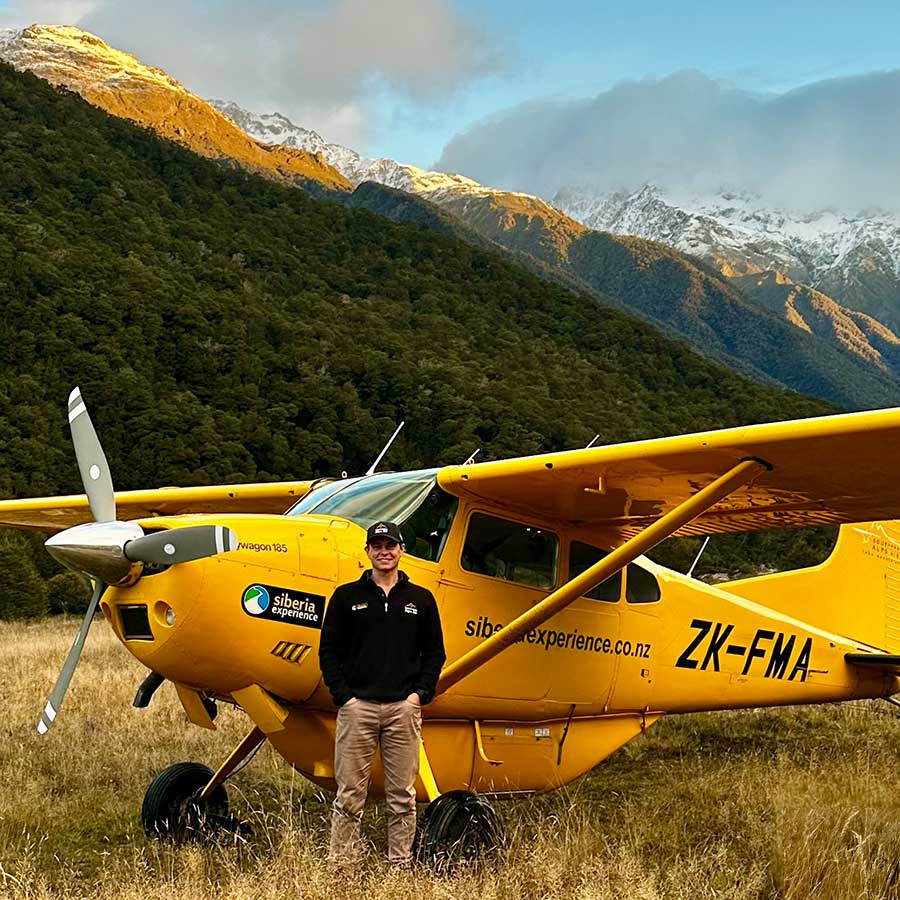 southern alps air team pilot hamish in front of buttercup the yellow plane